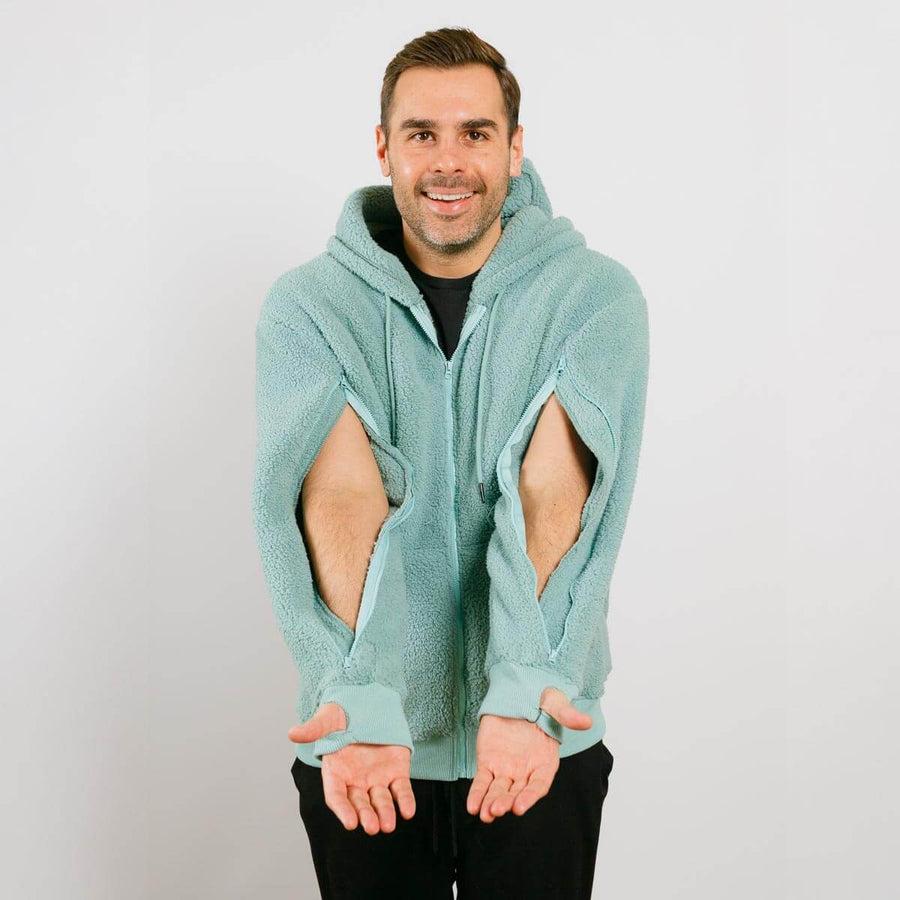Man wearing a light blue hoodie with cut-out design on a plain background