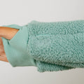 Person wearing seafoam color sherpa zip hoodie with ribbed cuff detail visible on arm.