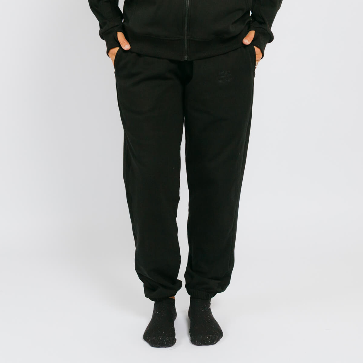 Black jogger sweatpants with cuffed ankles on a model wearing a matching black zip-up hoodie. | Model is 5'3" 130lbs wearing size S
