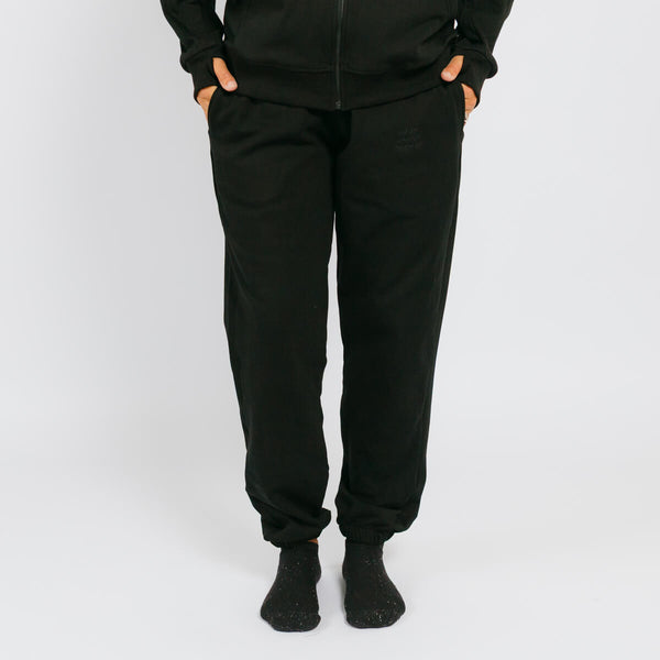 Black jogger sweatpants with cuffed ankles on a model wearing a matching black zip-up hoodie. | Model is 5'3" 130lbs wearing size S