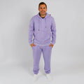 Man wearing lavender zip-up hoodie and matching sweatpants standing against white background. | Model is 5'8" 165lbs wearing size M