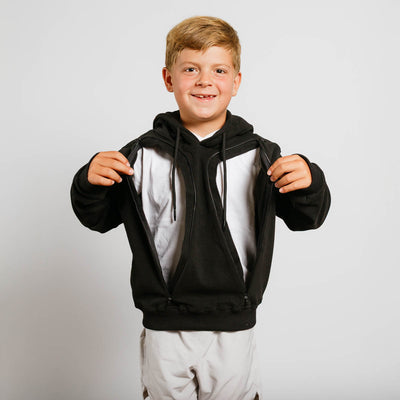 Boy wearing black zip-up hoodie with white undershirt, front view showing full-length hoodie.