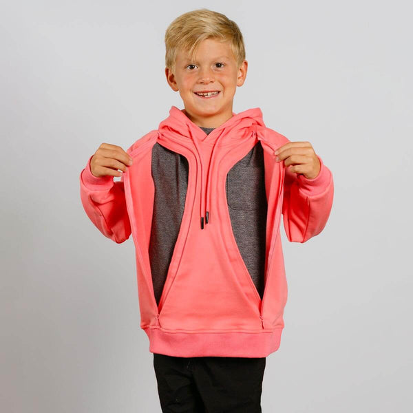 Young boy wearing a bright pink hooded sweatshirt over a gray shirt, smiling at camera. | Model is 4'1" 58lbs 7 yo,  wearing size YS