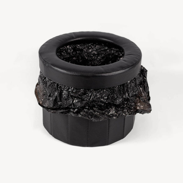 Black portable toilet with crumpled black bag inside.